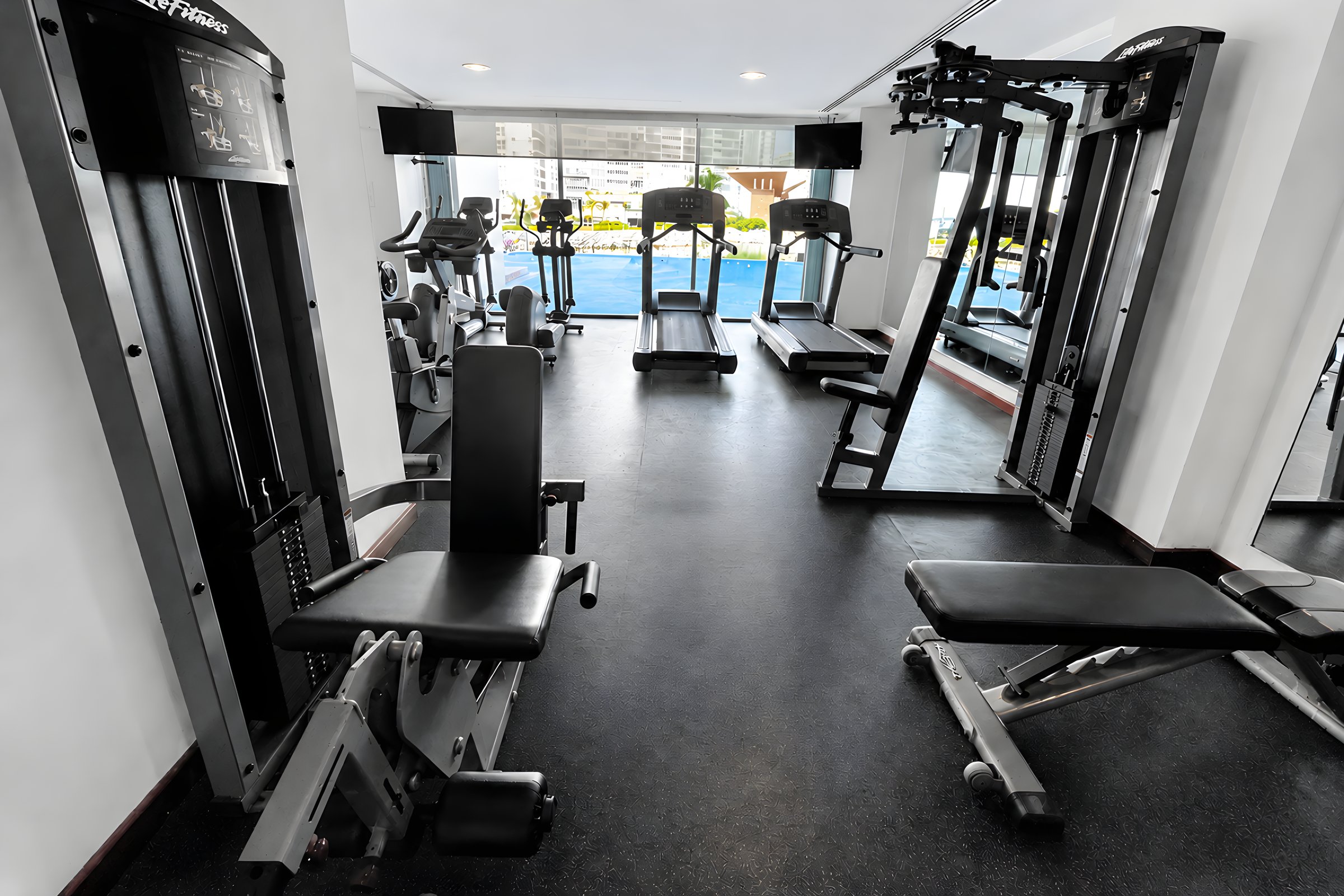 Gimnasio con equipo de cardio y estaciones de fuerza en Maioris Marina Residences, Puerto Cancún