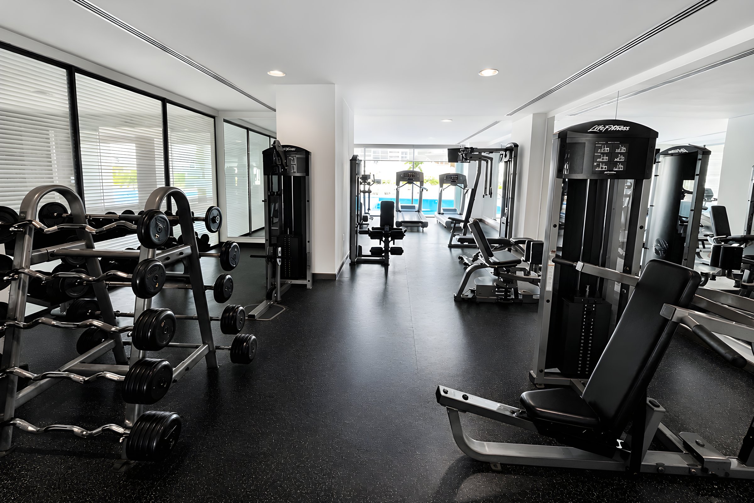 Gimnasio equipado con área de peso libre y máquinas en Maioris Marina Residences, Puerto Cancún