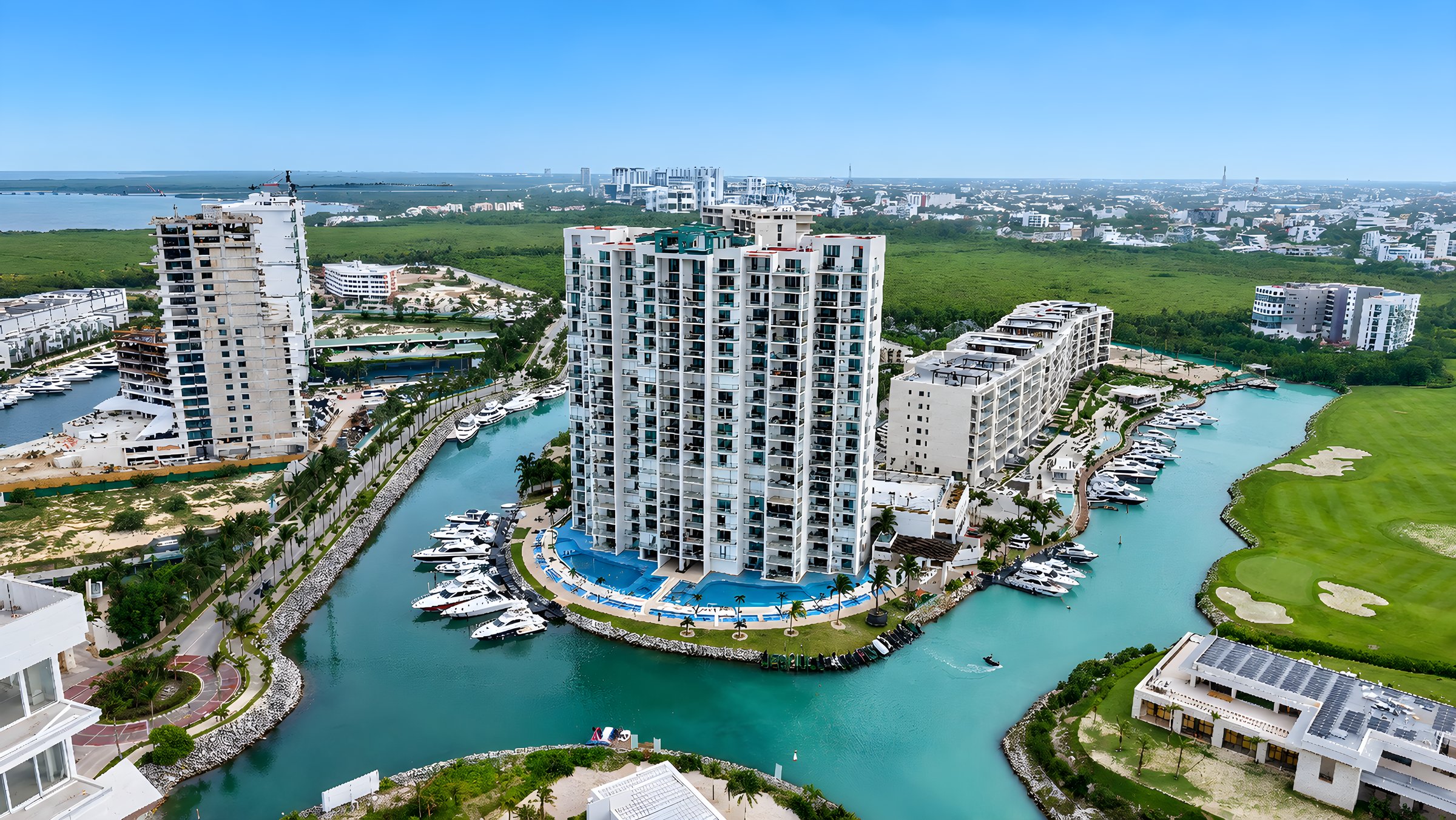 Vista aérea del conjunto Maioris Marina Residences, sus albercas, la marina y el campo de golf de Puerto Cancún