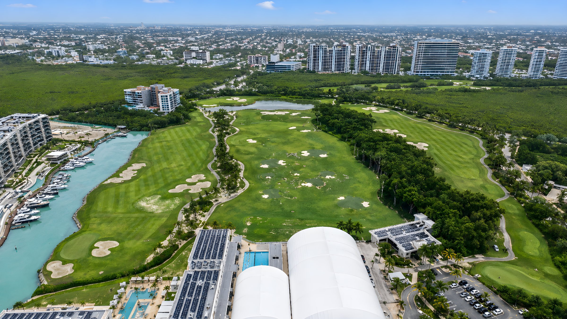 Campo de golf de Puerto Cancún junto a la marina y las torres de Maioris Marina Residences, vista aérea