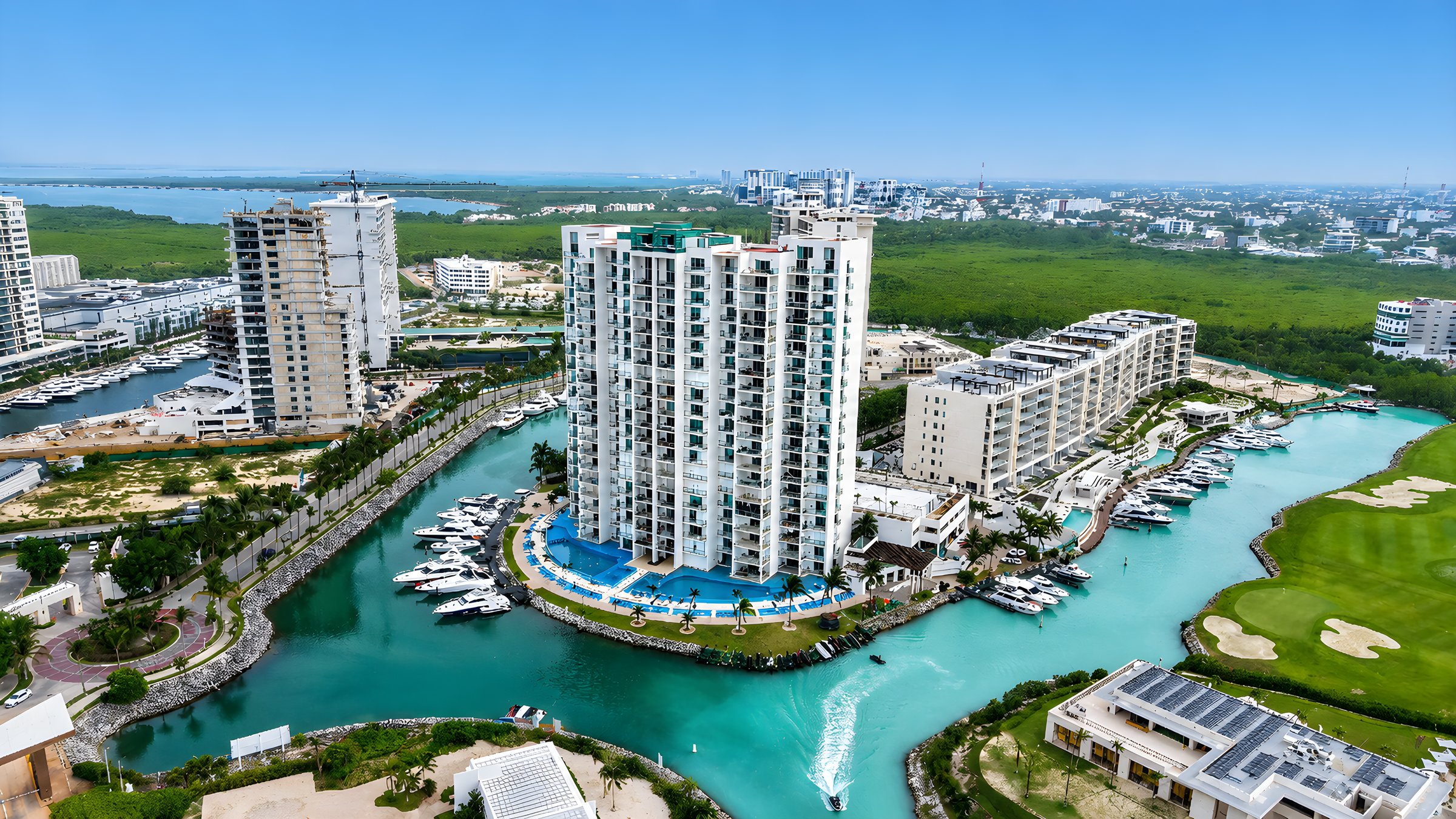 Torre de Maioris Marina Residences entre la marina privada y el canal de yates de Puerto Cancún, vista aérea de dron